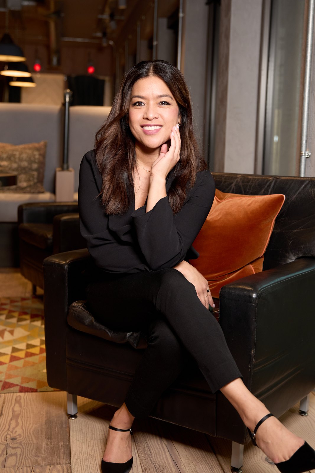 Mitzi Benavides, seated and smiling